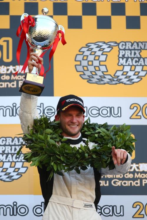 Maro Engel mit Siegerkranz streckt den Pokal in die Luft