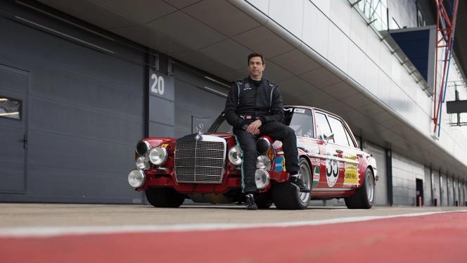 Bild von Toto Wolff auf der Motorhaube der „Roten Sau“ sitzend