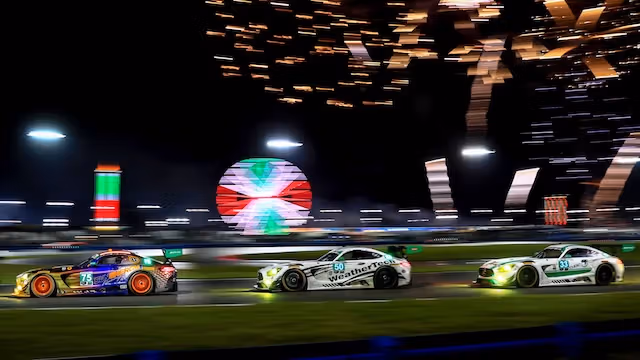 Drei Mercedes-AMG GTs mit Feuerwerk im Hintergrund
