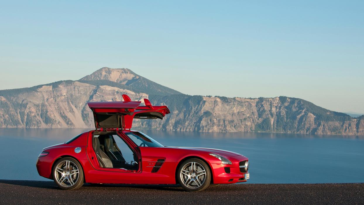 Ein roter AMG SLS vor einer malerischen Landschaft